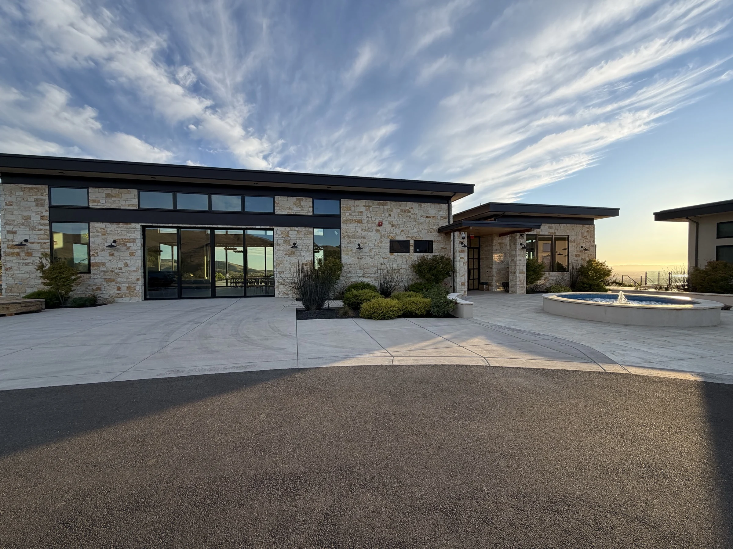 Stone and glass winery opening onto a courtyard in the Napa evening light
