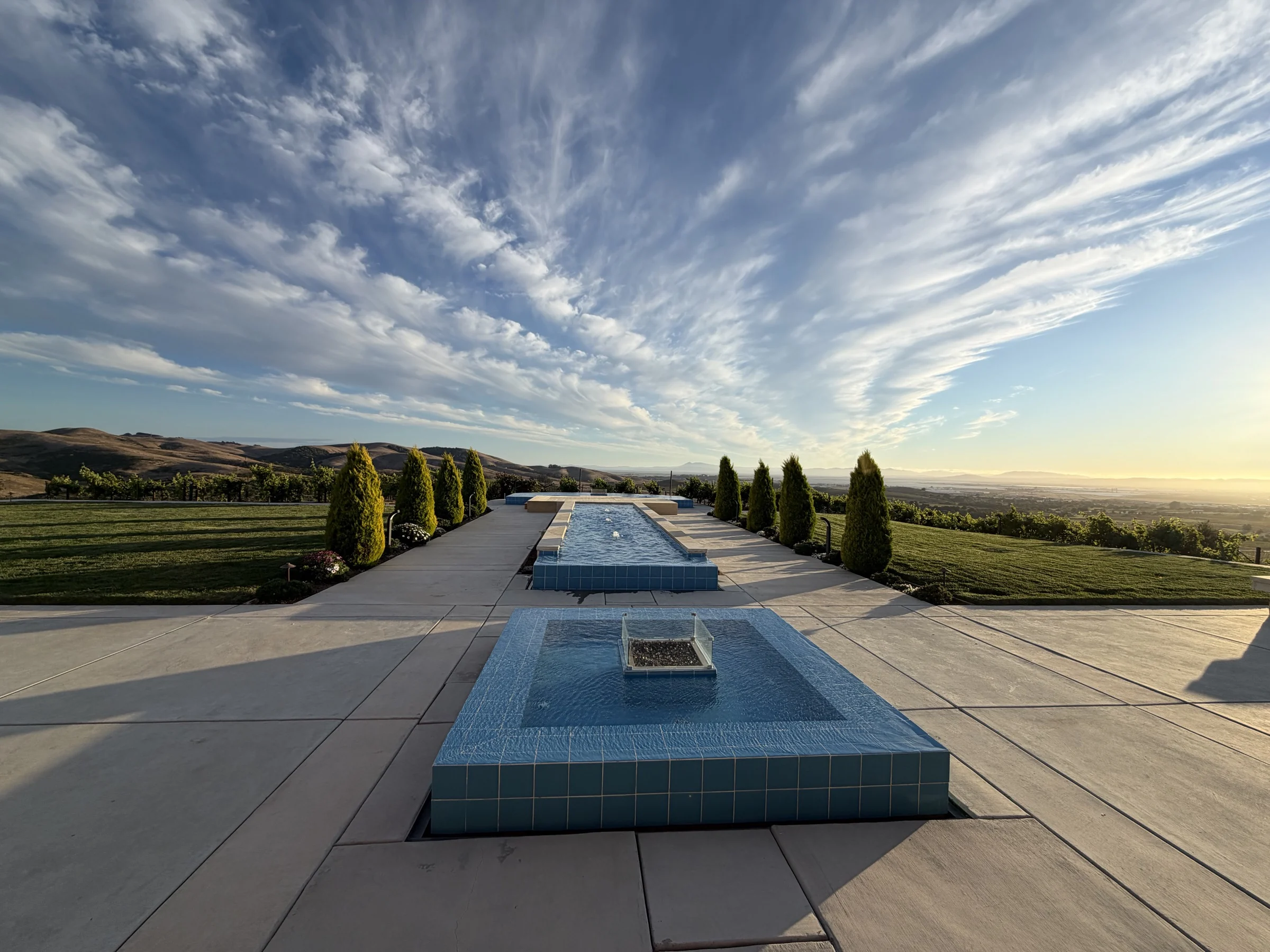 Reflecting pools and cypress-lined garden terraces with an open view across Napa Valley